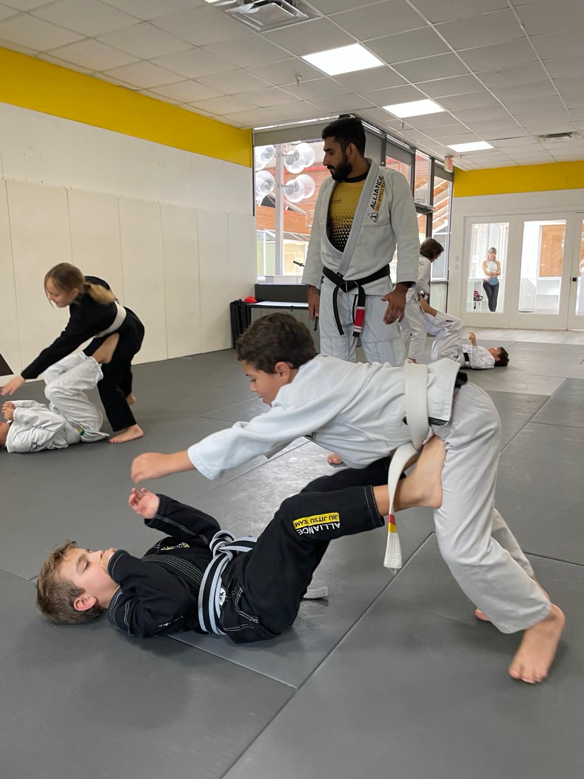 Kids practicing takedowns during class