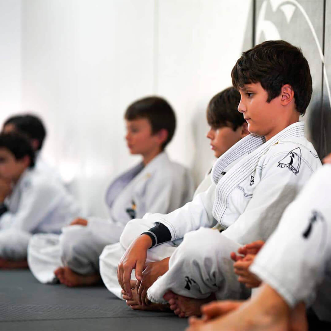 Kids class listening to instruction on the mat